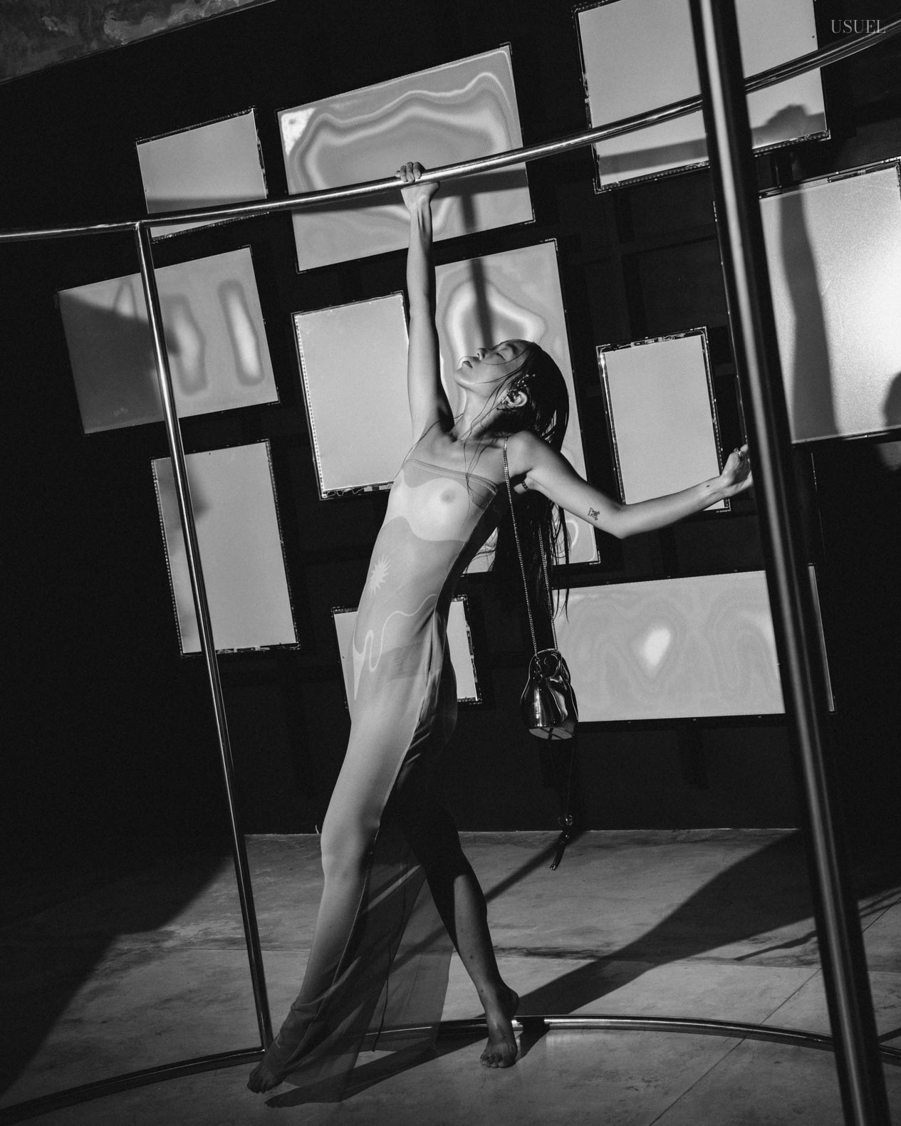 Model Michelle Putri in a sheer Di Petsa dress, posing amidst geometric frames and mirrors