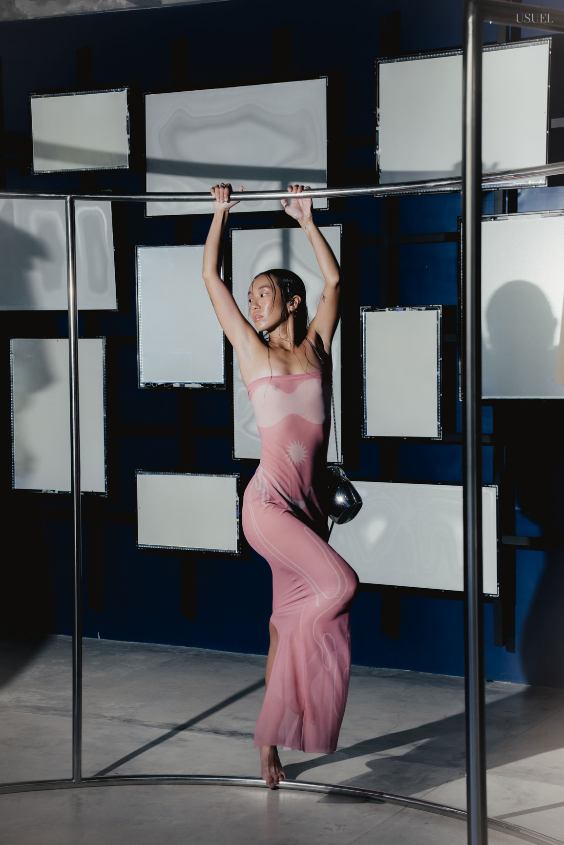 Model Michelle Putri in a sheer Di Petsa dress, posing amidst geometric frames and mirrors