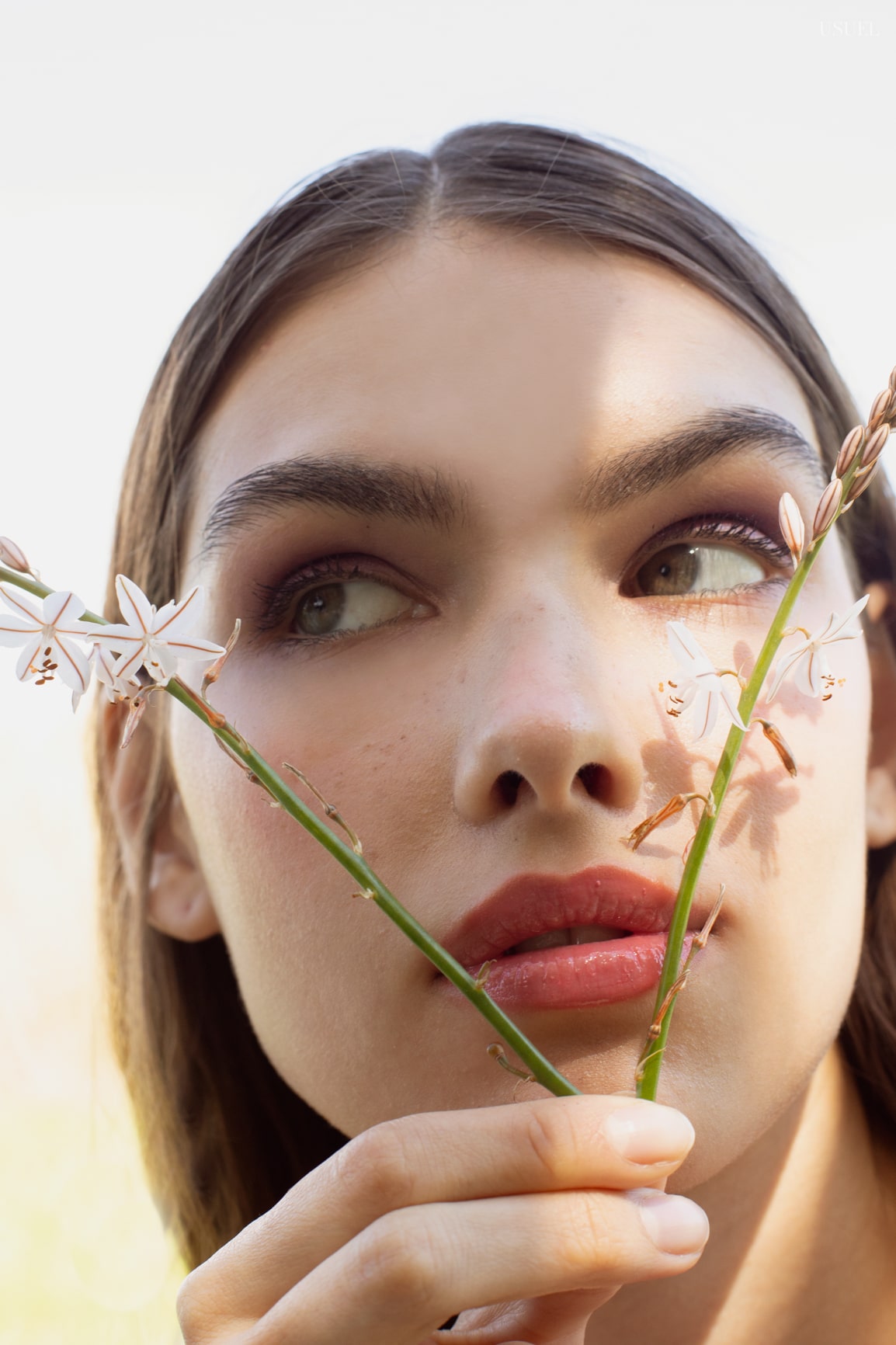 Model Lina wearing light, flowing garments made of tulle and lace, standing in the grass.