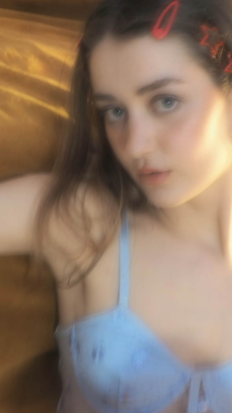 Woman in light blue lingerie lying on a wooden floor