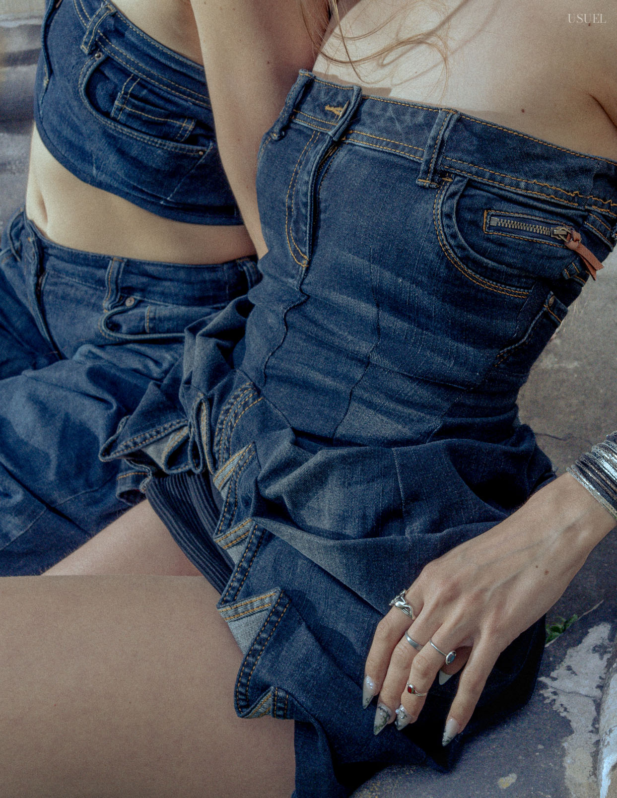 Two women wearing denim outfits, standing close to each other in an expressive pose